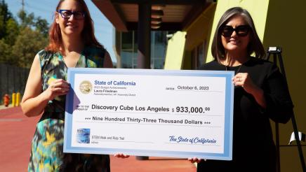 Assemblymember Laura Friedman and Los Angeles City Councilmember Monica Rodriguez pose with Discovery Cube check.