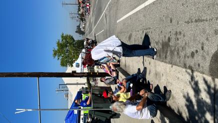 Assemblymember Friedman gives candy to child watching parade.