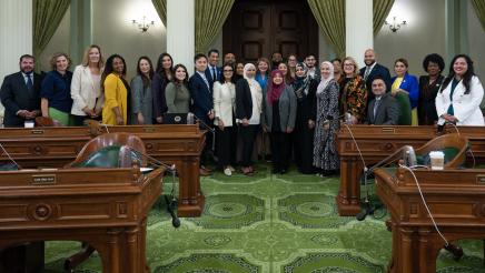 The Assembly poses with HR 52 sponsors to celebrate the passage of the resolution.