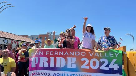 Assemblymember Laura Friedman throwing hats to the watching crowd